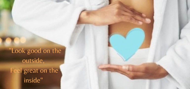 Person in a bathrobe forming a heart shape over their stomach.